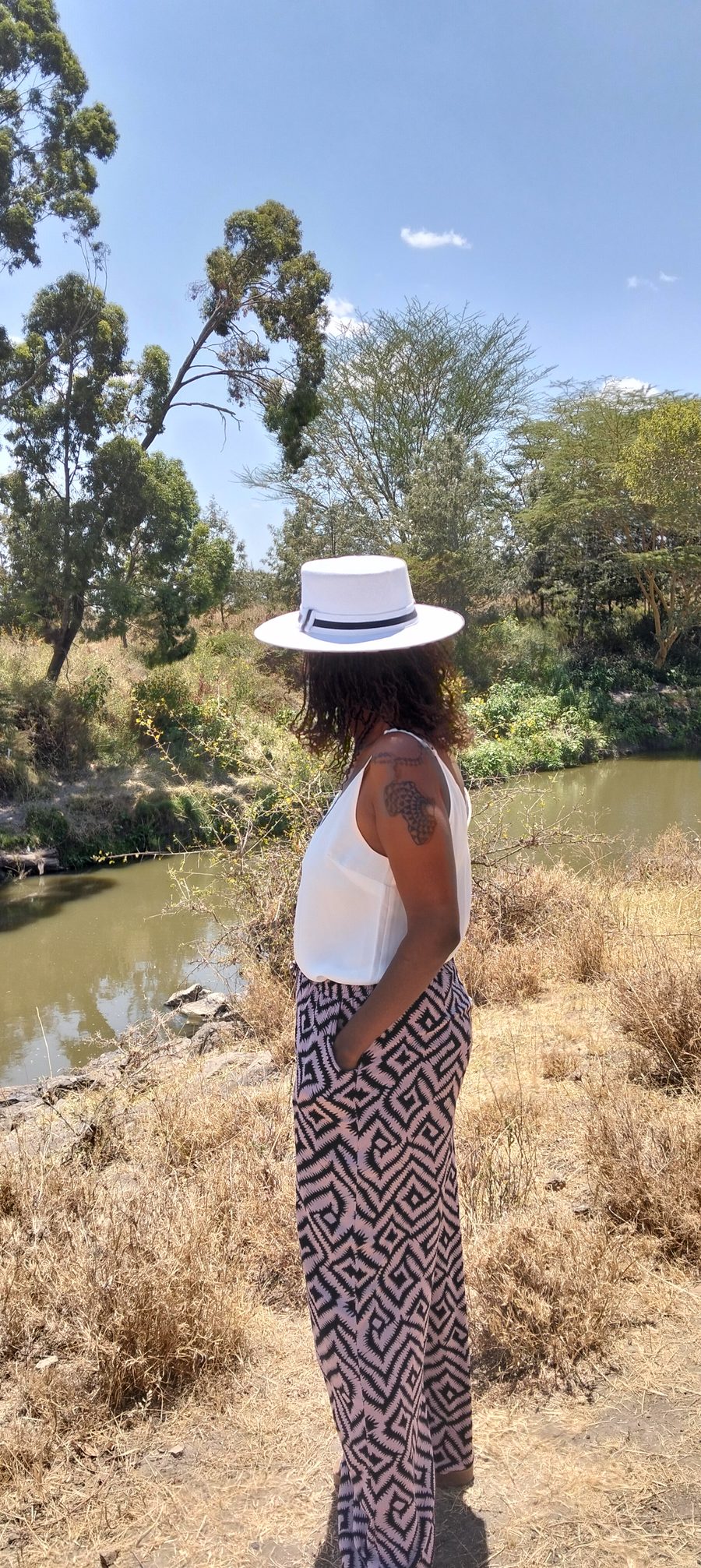 Carol Wanjeru, founder of Uhai Forest Trust, standing beside the river on the Kamulu site